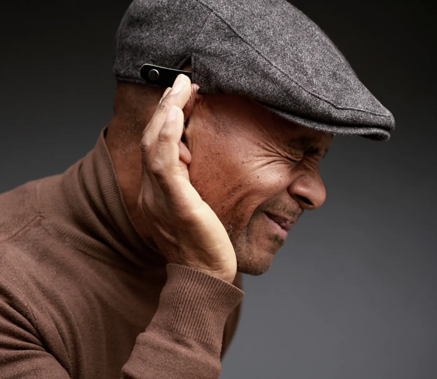 Older man struggling to hear a conversation